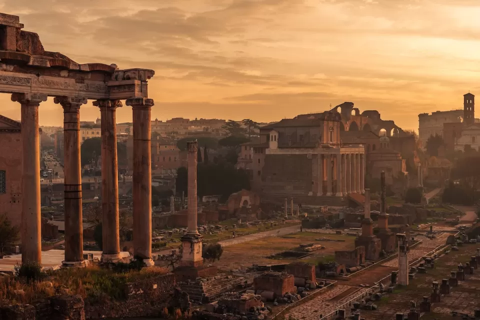 Roman Forum ruins in Rome, Italy with dusk sky.